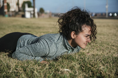 Portrait of young woman lying on field