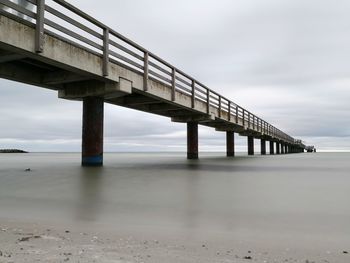 Low angle view of bridge over sea against sky