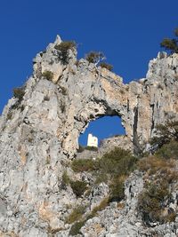 Low angle view of old ruins against clear blue sky