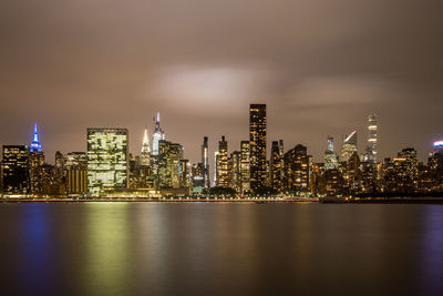 Illuminated buildings in city against sky at night