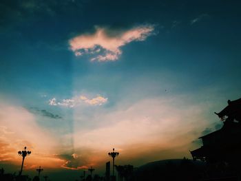 Silhouette of building against cloudy sky