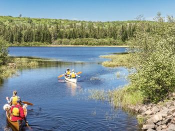 People in lake against sky