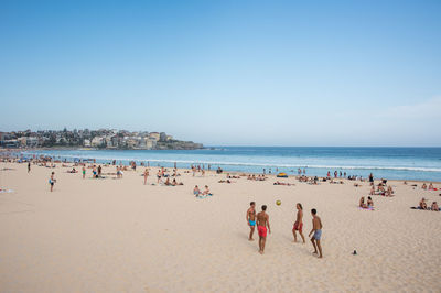 Crowd at beach against sky