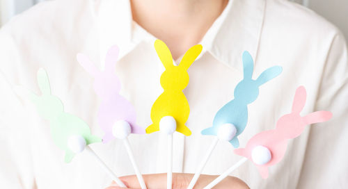 Easter bunny figurines of different colors in women's hands. preparing for the holiday.