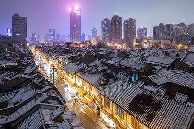 High angle view of illuminated buildings in city at night