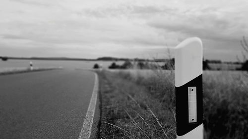 Information sign on road against sky