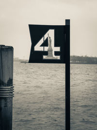 Statue of liberty seen through number 4 sign against sky