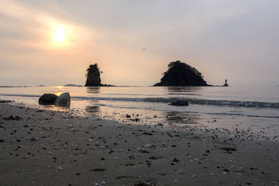 Scenic view of beach against sky during sunset