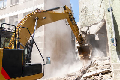 Process of demolition of old building dismantling. excavator breaking house. 