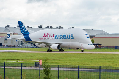 Airplane on airport runway against sky