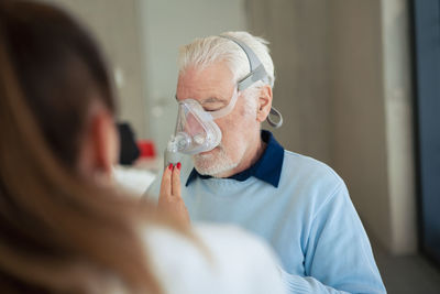 Doctor helping patient using nebulizer