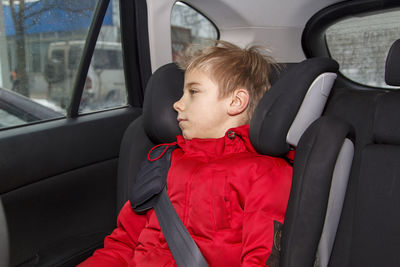 Thoughtful boy sitting in car