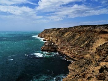 Rock formations by sea against sky