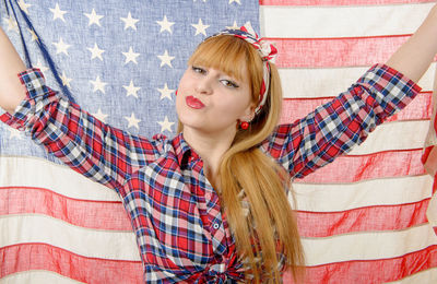 Portrait of beautiful young woman holding american flag