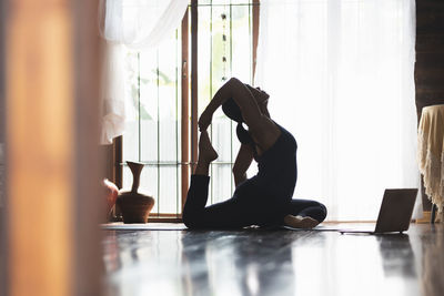 Side view of woman exercising in gym