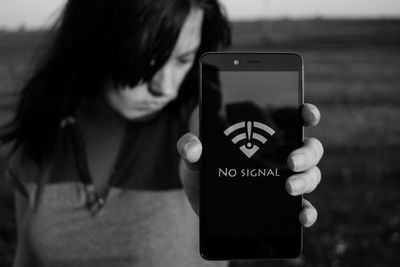 Woman showing no signal sign on smart phone