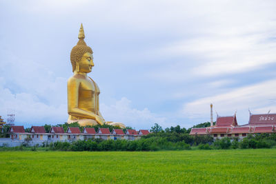 Statue of temple against building and sky