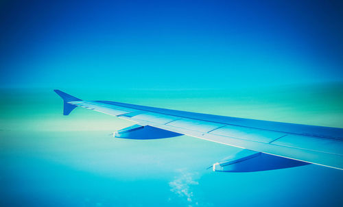 Aerial view of airplane wing against clear blue sky