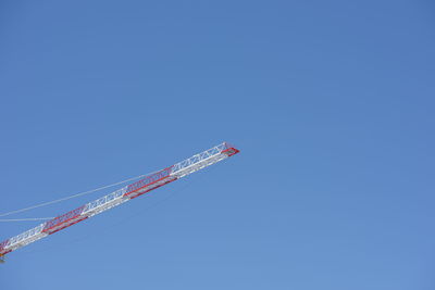 Low angle view of airplane flying against clear blue sky