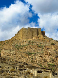 Low angle view of old building against cloudy sky