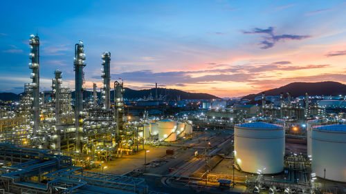 Aerial view oil and gas tank with oil refinery background at night, glitter lighting petrochemical.