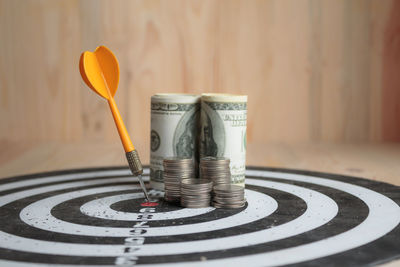 Close-up of dart and currencies on board