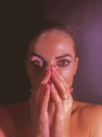 Close-up of young woman with eyes closed against black background