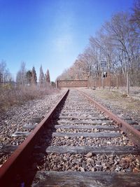 View of railroad track along bare trees