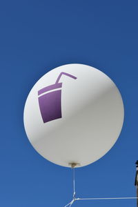 Low angle view of balloons against blue sky