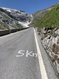 Road leading towards mountains against sky