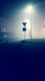 Illuminated street light against sky at night