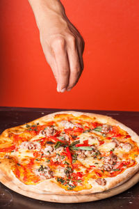 Cropped image of hand holding pizza