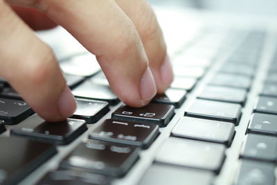Close-up of person typing on laptop