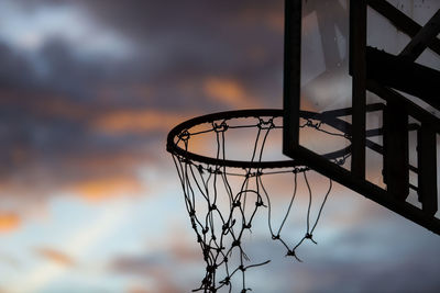 Low angle view of basketball hoop against sky during sunset