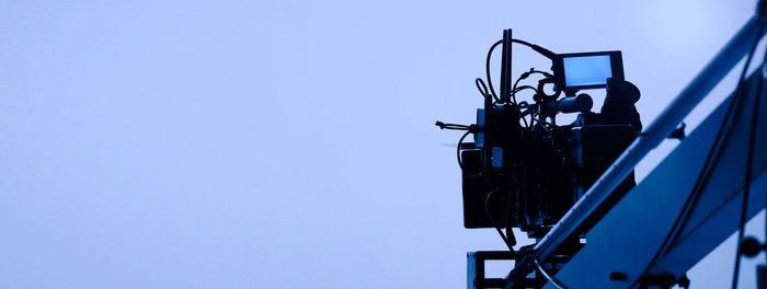 Low angle view of ferris wheel against clear blue sky