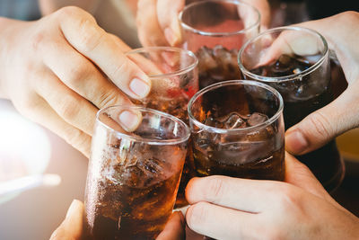 Cropped hands of people toasting drinks