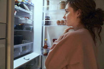 Side view of young woman standing in store