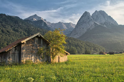 Scenic view of field by mountains against sky