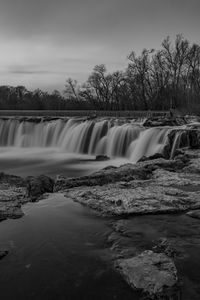 Scenic view of waterfall against sky