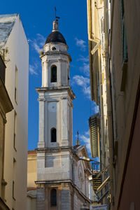 Low angle view of bell tower against sky in city