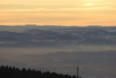 Scenic view of silhouette mountains against orange sky