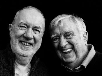 Portrait of smiling senior men against black background