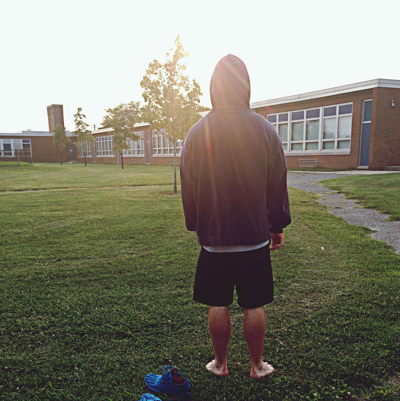 grass, building exterior, lifestyles, architecture, casual clothing, built structure, standing, full length, leisure activity, rear view, clear sky, walking, field, men, three quarter length, front view, day, young adult