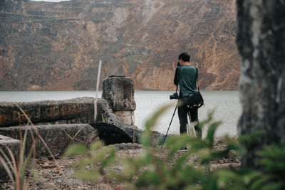 Rear view of man standing by rocks