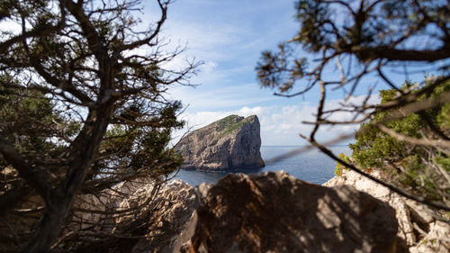 Scenic view of rocks by sea against sky