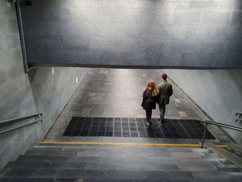 Rear view of people walking on staircase