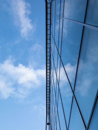 Low angle view of suspension bridge against cloudy sky