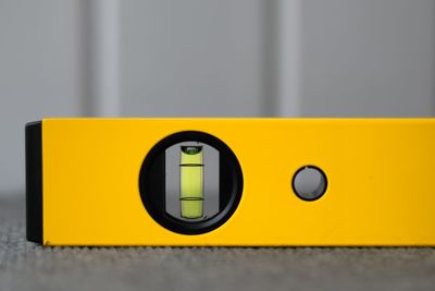 Close-up of yellow telephone on table against wall