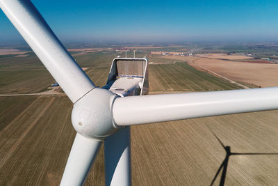 Aerial view of close up windmill turbine in countryside area, wind power and renewable energy