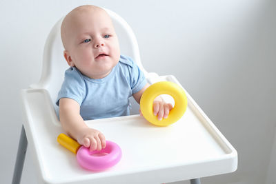 Portrait of cute baby boy eating food at home